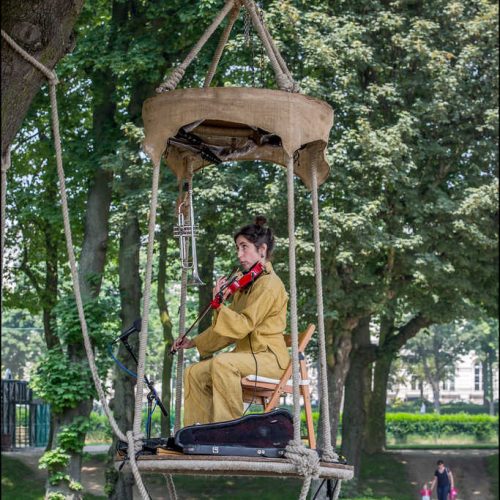 Milieufestival violist speelt viool op een hooggelegen hut