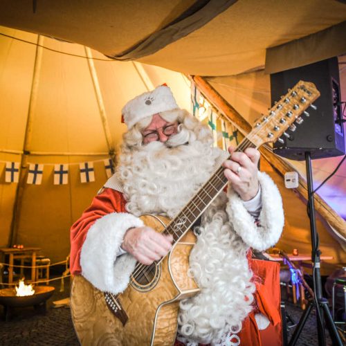 Plaisirs d'hiver le père noêl joue de la guitare